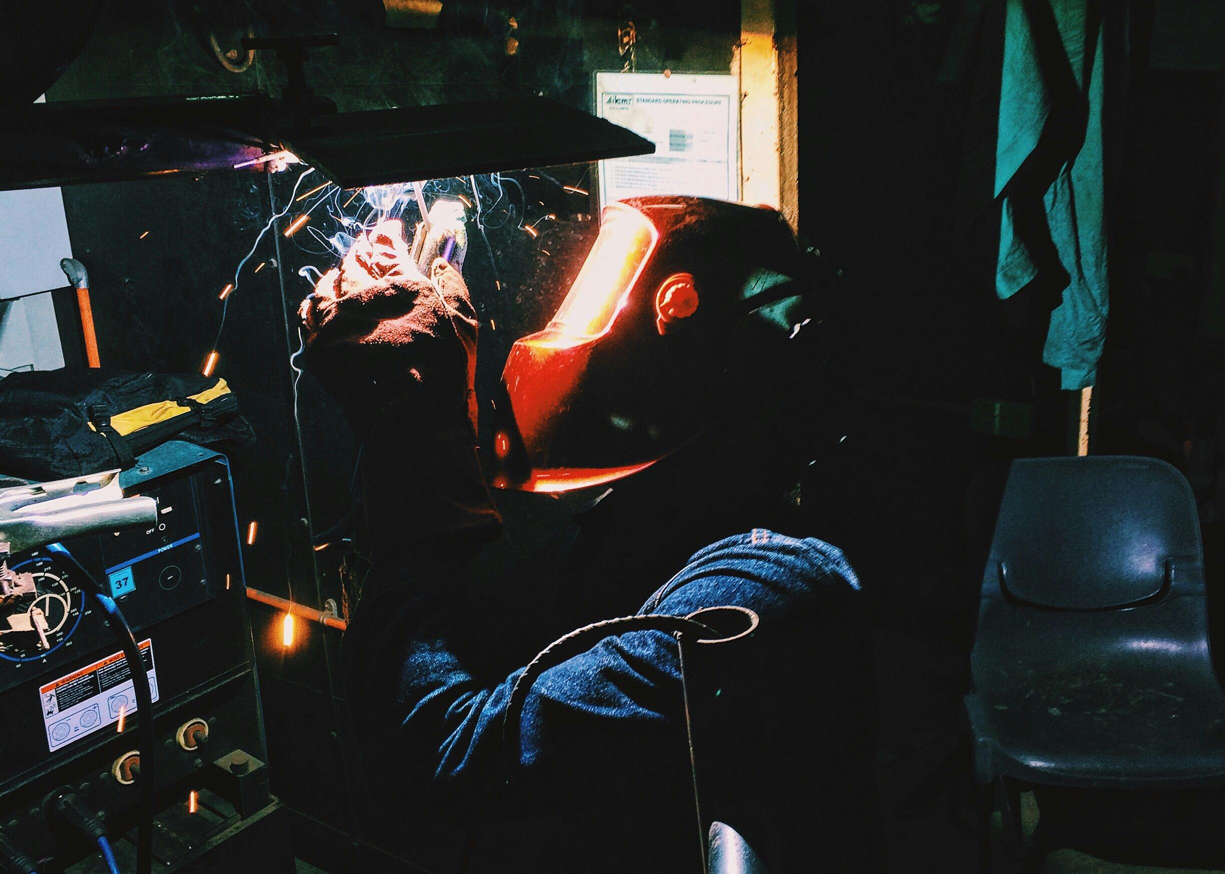 Welder performing MIG welding showing wire and gas setup